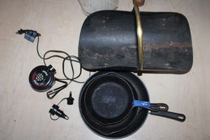 lot 415 image: Cast iron pans, skillet, inflator, and metal firewood caddy