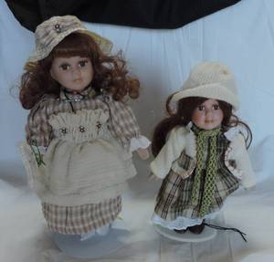 lot 84 image: Two porcelain dolls one approximately 13 inches the other approximately 10 inches