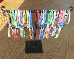 lot 256 image: Around 50 zipper bracelets and metal stand