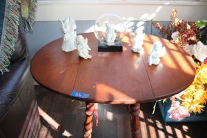 lot 26 image: Small dual drop leaf table with angel figurines
