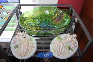 lot 130 image: Kissing couple plaques, green glass grape bowl and metal stand