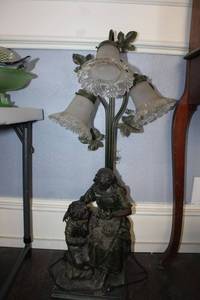 lot 47 image: Cast iron base table lamp. Boy and girl design with bird nest and 3 glass globes, see photos.