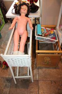lot 233 image: Wicker plant stand, large plastic doll, doll crib as shown, and toys