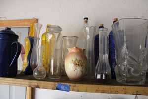lot 462 image: Blue, yellow and clear glass bottles, clear vases, metal blue pitcher