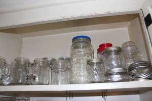 lot 353 image: Cabinet full of Glass Jars,, Empty Jelly Mugs, Canning Jars, extra rings and more
