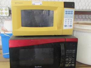 lot 30 image: well used yellow and a  red microwave both need cleaned