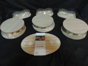 lot 12 image: Three wood food holders with glass tops one wood cutting board three packs of risers 2 in each pack