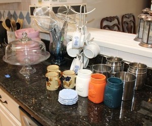 lot 43 image: Kitchen mugs, cake plate with lid, pink cannister and utensils as shown