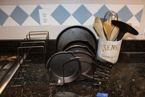 lot 44 image: Cast iron pans, storage racks, and utensil holder