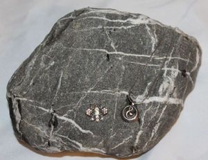 lot 1 image: Large Wishing Rock with Two Sterling Silver Necklaces, with small pendants, clear stones on a butterfly and Circular pendant with a moon in the center reads love you to the moon and back