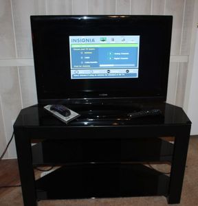 lot 207 image: Insignia, 32 LCD Television with DVD Player Built In, Remote, and Television Stand 40x18x24