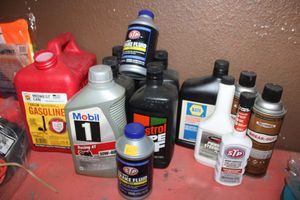 lot 18 image: Automotive lot motor oil, brake fluid, fuel treatment, power steering fluid, anti-seize lubricant, transmission fluid, gas can