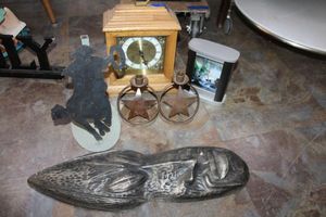 lot 260 image: Home dcor desk clocks, metal star candle holders, iron cowboy silhouette paper towel holder, and tribal mask wall hanging