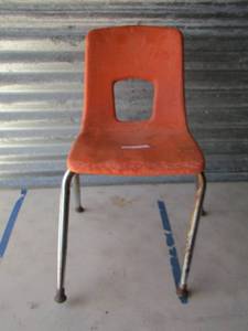 lot 221 image: orange childs chair, front leg needs to be bent back out