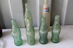 lot 163 image: Vintage Coke bottles and one vintage Pepsi bottle