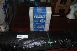 lot 97 image: Two boxes of Fabric and Garden Staples and Black Plastic Fabric