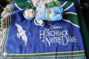 lot 284 image: reborn baby doll and a Disney the hunchback of Notre dame throw blanket