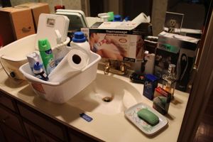 lot 27 image: Bathroom lot colognes, home hair trimmer kit, travel shaver, Thermassage, cleaners, foot spa, and scale