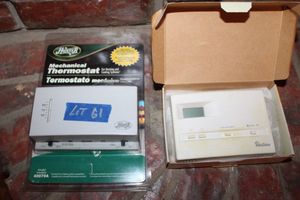 lot 61 image: Mechanical thermostat (unopened) and used thermostat