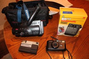 lot 90 image: Camera lot Samsung video cam, Challenger disc cam, Canon sure shot, and Kodak Polaroid