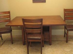 lot 17 image: DROP DOWN DINING TABLE 29-126244 with sides up, both sides fold down leaving it at 26 wide from 44 wide beautiful  w a cabinet in base with 3 chairs
