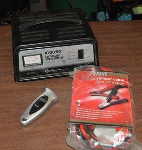 lot 281 image: Battery Jumperslow charge box, Jumper Cables, and Digital Tire pressure Gauge
