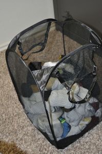 lot 167 image: Collapsable Mesh Hamper half full of matched and paired Mens socks