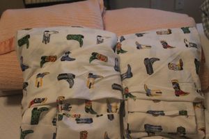 lot 82 image: Two Sets of Twin Cowboy Boots Sheet Sets, Each Includes Fitted and Flat  Sheets with Three Pillow Cases and Two Pink Blankets