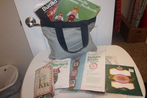 lot 109 image: Bag of NeedlepointCrosstitch Projects, Thread and Pattern Books. Projects are partially done, some almost done and some just started. Lots of Christmas patterns