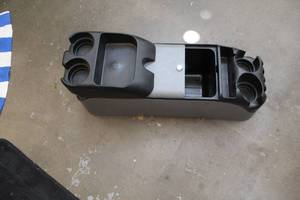 lot 101 image: Storage cubby with drink holders for in between seats and possibly a van