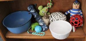 lot 157 image: Gently used dog toys and two dog bowls one metal one glass the white one has a small chip as seen in picture
