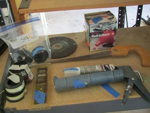 lot 180 image: small rolls of weed eater string, caulking gun, raft inflator and more