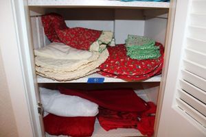 lot 51 image: Bright red Christmas table linens, tree skirt, and white lacy table cover