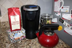 lot 205 image: Keurig coffee maker (powered on), tea kettle, and coffee