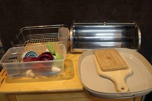 lot 406 image: Mixed lot of kitchen things metal bread Box two serving trays cutting boards measuring cups and some utensils and more