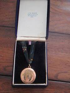 lot 40 image: JEWELRY - GOLD BROACH W INSET BLUE STONES ON A RIBBON FOR USE AS A NESCKLACE IN A JW Bader JEWELER BOX L