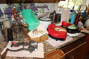 lot 59 image: Misc. kitchen items vintage meat grinder, mini crockpot, quesadilla maker, over-the-sink strainer and more
