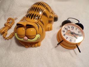 lot 5 image: Lot- Vintage Garfield landline telephone by Tyco from the 1980s And a Garfield metal wind-up alarm clock by Sunbeam