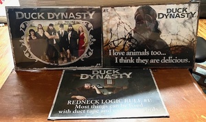 lot 87 image: Three (3) Duck Dynasty Metal Signs - Still in Plastic