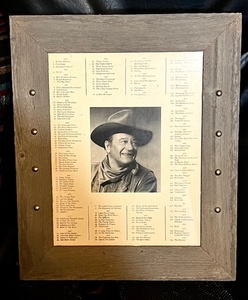 lot 98 image: Framed List of John Wayne Movies WSuprise Additional Photo on Back