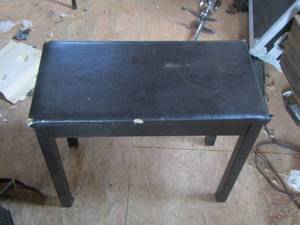 lot 1007 image: Black piano bench with minor damage it is pictured