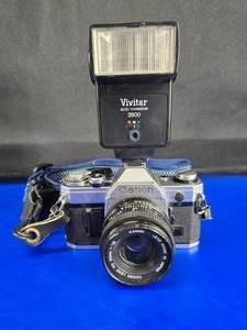 lot 205 image: Vintage Canon AE-1 SLR 35mm Camera w Canon 50mm 11.8 Lens & Vivitar 2800 Flash.  LOOK THIS ONE UP