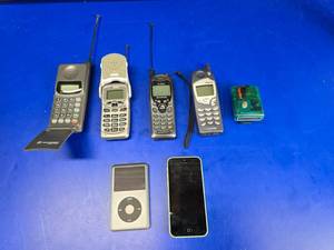 lot 207 image: About 30 Years of Technology Progression In One Photo.  Includes Lot of Old Phones, Translucent Teal Motorola Pager (This was the BOMB in the 90s), iPhone & iPod 160GB Model A1238.  LOOK UP HOW EXPENSIVE THE IPOD IS