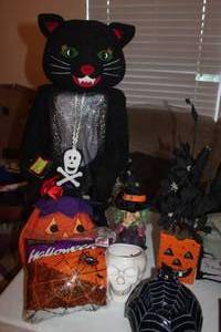 lot 123 image: Plush Black Cat, Ceramic Dcor Items, Spider Webbing and Black Floral Arrangement, Light Up Plush Pumkin (needs Batteries)
