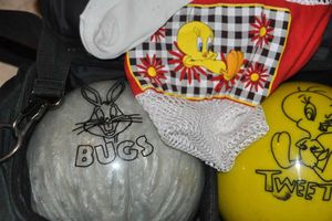 lot 5 image: Bugs Bunny and Tweety Bowling Balls, Tweety Shirt, Socks, and Keychain, Double Bowling Ball Bag