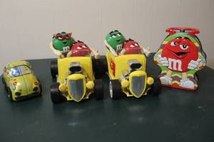 lot 296 image: 2 M&Ms Rebel Without A Clue Hot Rod Candy Dispenser. And vintage M&Ms collectible tin shaped like a yellow Volkswagen Beetle car. and collectible M&Ms Red character tin lunch box, likely from 2003