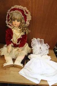 lot 17 image: Large porcelain doll with soft body and a extra outfit