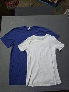 lot 66 image: 2 Boxes of Bella Canvas Shirts.  Includes 1 Box of 3413 Unisex Tri-Blend Royal Blue Heather Adult Tee Shirts & 1 Box of 6400 Womens Relaxed Fit 100% Soft Cotton Silver Adult Tee Shirts.  BID IS TIMES THE QUANTITY SO YOU ARE BIDDING PER BOX