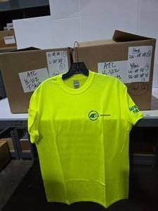 lot 363 image: 3 Boxes of ATC Drivetrain Neon Yellow Shirts.  Approx 54 Shirts Total