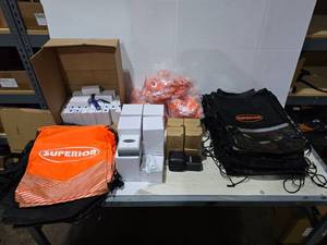 lot 592 image: Large Lot of Misc Superior Drawstring Backpacks, Flashlights, Desktop Wireless Charging Stations, Tote Bags, Travel Adapters & Earbuds
